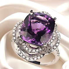 Delightful cocktail ring of cushion cut Amethyst, 7.63ct, in 14K white gold setting featuring 0.61ct of Diamonds. The two looping halos of Diamonds create an elegant and dramatic setting for this lovely Amethyst. The diamonds continue down the top of the shank of the ring. No changes by seller. This is a sizable 6.5 which your local jeweler can assist you with if you should need to size. MR2350 Amethyst Cocktail Ring, White Gold Set, Ring With Diamond, February Birthstone, Purple Hues, February Birth Stone, Diamond Halo, Brilliant Diamond, Sparkle Diamonds