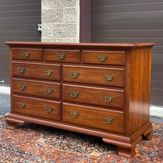 a large wooden dresser sitting on top of a rug next to a wall and door