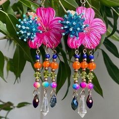 Oh we are definitely having way too much fun here.  I think it's cos we're in Ireland and it's raining constantly so we made tropical earrings to bring the sun to us!   I've used gorgeous painted resin hibiscus flowers and paired them with stunning blue beaded clusters.  I've got all fringy with the fringe thing and hung blue glass beads, orange pumpkin beads, green bicones and rainbow crystals.  I've finished off with gorgeous fire polished drops in purple and blue and a stonker of a clear crys Multicolor Flower Earrings For Summer Beach, Bohemian Flower Earrings For Vacation, Handmade Bohemian Flower Earrings For Vacation, Pink Flower-shaped Jewelry For Vacation, Pink Flower Jewelry For Vacation, Pink Resin Jewelry For Summer, Summer Pink Resin Jewelry, Beach Fun Drop Earrings Jewelry, Colorful Drop Earrings For Beach