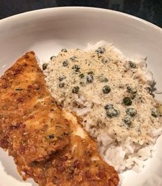 a white plate topped with rice and meat