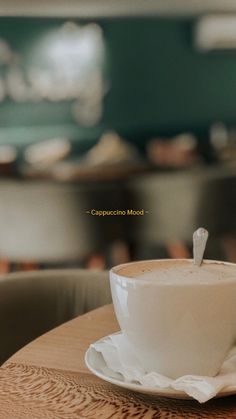 a cappuccino mug sitting on top of a wooden table