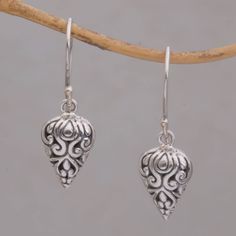 Wayan Asmana proudly presents a regal pair of dangle earrings from Bali in celebration of local craftsmanship. Crafted of sterling silver by local artisans each earring takes a pointed shape elaborated with swirling vine patterns. Ornate Drop Earrings For Gifts, Sterling Silver Dangle Jewelry For Celebrations, Ornate Drop Earrings Gift, Traditional Sterling Silver Teardrop Earrings As Gift, Elegant Sterling Silver Danglers For Gift, Elegant Sterling Silver Danglers As Gift, Artisan Sterling Silver Drop Earrings, Artisan Long Drop Sterling Silver Earrings, Artisan Dangle Earrings For Anniversary