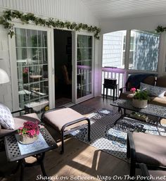 a living room filled with furniture on top of a hard wood floor covered in plants