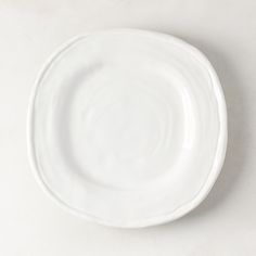 an empty white plate on a plain surface