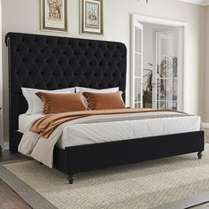 a bedroom with a bed, rugs and pictures on the wall above it is shown