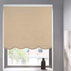 a window with a white roman blind in front of it and a black vase on the windowsill