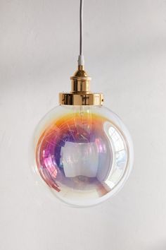 a shiny glass ball hanging from a ceiling light with a gold colored metal fittings