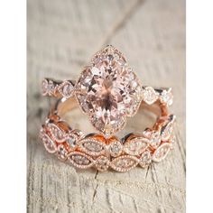 an image of two wedding rings set with morganite and diamond accents on wood background