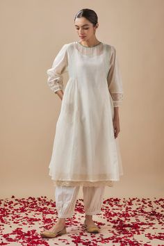 Ivory puffed sleeves side gathers anarkali with pintucks on the side, lace and sequin embellishments on the neckline and sleeves hem. Paired with a gathered salwar pant and an inner. - Aza Fashions Elegant Cream Cotton Anarkali Set, Cream Cotton Elegant Salwar Kameez, Elegant Cream Cotton Salwar Kameez, Elegant White Cotton Anarkali Set, Elegant Cotton Anarkali Set With Cutdana, Elegant Cotton Silk Salwar Kameez With Embroidered Sleeves, Bollywood Salwar Kameez With Embroidered Sleeves For Wedding, Bollywood Style Wedding Salwar Kameez With Embroidered Sleeves, Eid White Kurta With Embroidered Sleeves