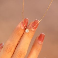 a woman's hand with a diamond ring on it and a gold chain necklace