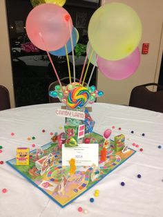 a table topped with lots of balloons on top of a white table cloth covered table