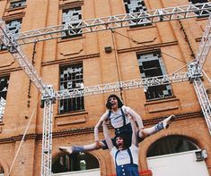 two people doing acrobatic tricks in front of an old building