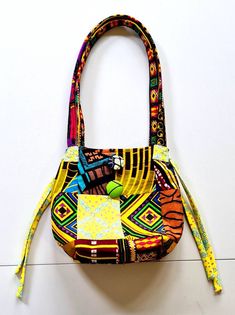 "This beautiful Patchwork Bag  is made from a combination of African printed fabrics. I saw this style of patchworking when I visited Gambia and couldn't resist using this technique to make a bag. Inside you will find a compartment to hold your phone, keys or change and closes with a button. Size = 8 5\" x 10\" Why not match it up with a pair of matching earrings? https://www.etsy.com/uk/ZemoraZemora/listing/1270815833/sunshine-earrings-summer-earrings-fabric?utm_source=Copy&utm_medium=ListingMa Daily Use Patchwork Satchel Hobo Bag, Patchwork Satchel Hobo Bag For Daily Use, Patchwork Satchel Hobo Bag For Everyday Use, Multicolor Patchwork Hobo Bag For Daily Use, Multicolor Patchwork Hobo Bag For Everyday Use, Multicolor Patchwork Tote Satchel, Multicolor Patchwork Satchel Bag, Multicolor Patchwork Satchel Shoulder Bag, Multicolor Bucket Bag With Removable Pouch