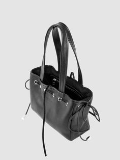 Crafted from our soft black leather and adorned with silver grommets and a leather side bow, this shoulder bag is sure to turn heads. Despite its compact size, the DREW offers ample space and functionality. Its interior, lined with organic cotton twill, includes a zipper pocket for easy organization. A top tie closure ensures safekeeping. Measuring 9" x 7" x 3.5" with an 8.5" strap drop. Silver-tone Hardware Bucket Shoulder Bag, Bucket Bag With Silver-tone Hardware And Double Handle, Casual Hobo Satchel Bag With Silver-tone Hardware, Casual Satchel Hobo Bag With Silver-tone Hardware, Everyday Bucket Satchel With Silver-tone Hardware, Casual Satchel Shoulder Bag With Silver-tone Hardware, Casual Shoulder Bag With Silver-tone Hardware And Double Handle, Casual Shoulder Bag With Silver-tone Hardware For Daily Use, Casual Satchel With Silver-tone Hardware