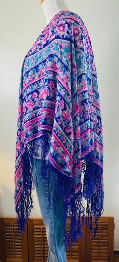 "Very Daisy Jones, here is a vintage shawl/scarf, purple with pink flowers and gray accents. Very delicate 100% pure silk with hand knotted purple fringe all around. Measures 36\" in diameter. PLEASE NOTE: This pretty vintage scarf does have some minor pinholes and one area where it has been mended, see photos. Still too beautiful to discard. Wear it as a wrap, drape it over a chair or table, many uses. Very cool." Floral Print Shawl Scarf One Size, One Size Floral Print Shawl Scarf, One Size Bohemian Scarf With Floral Print, Bohemian Scarves With Floral Print, One Size, Blue Floral Print Shawl For Spring, One Size Bohemian Scarves With Floral Print, Bohemian One-size Floral Print Scarves, Bohemian One Size Floral Print Scarves, Bohemian Blue Dupatta For Spring