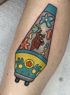 a cartoon character is on the leg of a person with a dog in a rocket ship tattoo