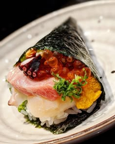 a white plate topped with sushi covered in toppings