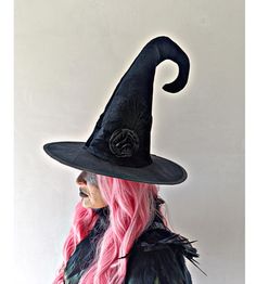 a woman with pink hair wearing a witches hat