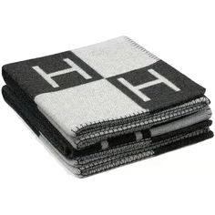 three black and white towels stacked on top of each other in front of a white background