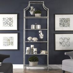 a metal shelving unit in a living room with blue walls and pictures on the wall