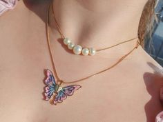 a woman wearing a necklace with a butterfly on it