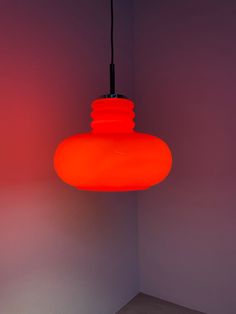 an orange light hanging from a ceiling in a room