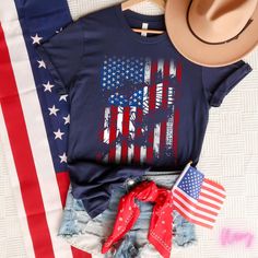 an american flag shirt and hat on top of a bed