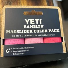 three different colored magnets in a box on top of a wooden table with the words yeti rambler