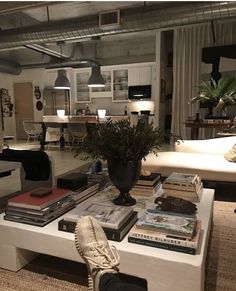 a person's feet resting on a coffee table filled with books