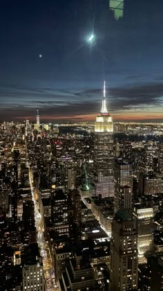 an aerial view of new york city at night with the empire building in the distance