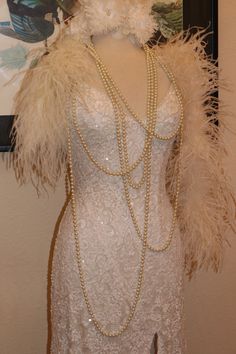 a mannequin with feathers and pearls on display