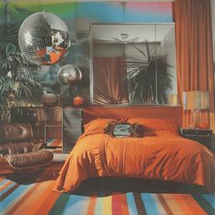 a bedroom decorated in orange and blue with disco balls hanging from the ceiling above the bed