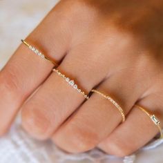 a woman's hand with three different rings on her fingers and one is wearing a diamond ring