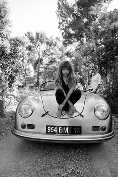 a woman sitting on the hood of a car