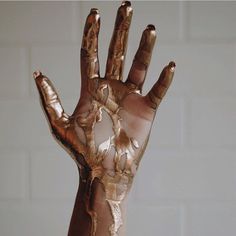 a person's hand covered in white and brown paint