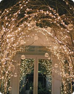 an archway decorated with christmas lights and ornaments