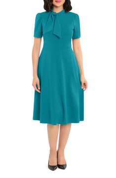 This dainty short sleeve dress is a retro inspired staple that's perfect for any well-dressed occasion. 45" length Necktie Short sleeves Back zip closure Lined 96% polyester, 4% spandex Hand wash, dry flat Imported Model Stats: 5'10" height; 34" bust; 27" waist; 35" hips. London Silhouette, Missy Dresses, Illusion Dress, Maggy London, Ladies Of London, Womens Tie, Dress Zipper, Short Sleeve Dress, Pocket Dress