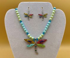 Colorful enamel and beaded dragonfly necklace, bracelet and earring set.  This is a great summer or beach set featuring a dragonfly in colorful enamel and seed beads.  Matching bracelet has an easy to use magnetic clasp.  Each piece has a custom length to fit all sizes.  Necklace is made from glass pearls and crystals to form a unique and stylish look.  Please do not hesitate to contact me with any questions, I would love to hear from you. Pendant Size : 2.0"L X 2.75"W  Earrings:  1.00" L Glass Summer Hypoallergenic Multicolor Jewelry, Adjustable Round Multicolor Jewelry Sets, Multicolor Adjustable Costume Jewelry Sets, Adjustable Multicolor Costume Jewelry Set, Adjustable Multicolor Metal Jewelry Sets, Multicolor Nickel-free Costume Jewelry, Hypoallergenic Round Beads Jewelry For Summer, Summer Hypoallergenic Jewelry With Round Beads, Summer Hypoallergenic Round Beads Jewelry