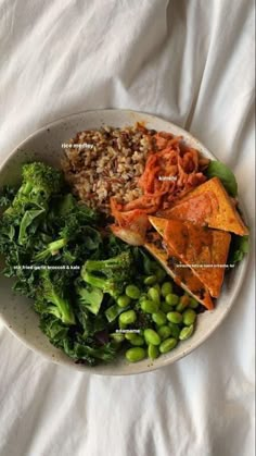 a white plate topped with lots of food on top of a bed