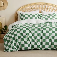 a green and white checkered comforter set on a bed in a room with wicker headboard