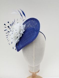 Bright blue fascinator/hatinator. I have made this striking fascinator in bright blue sinamay/straw. I have decorated it with a large hand made feather flower and clipped bright blue and white feathers. It is secured with a fine metal covered headband which can easily be hidden by your hair if desired. One size fits all Blue Fascinator With Short Brim For Summer, Blue Short Brim Fascinator For Summer, Blue Summer Fascinator Hat, Summer Blue Fascinator With Short Brim, Summer Sinamay Headpiece For Races, Blue Short-brimmed Fascinator For Summer, Spring Blue Fascinator With Short Brim, Summer Sinamay Fascinator For Races, Blue Fascinator With Curved Brim For Spring