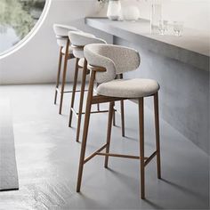 four bar stools are lined up in front of a counter