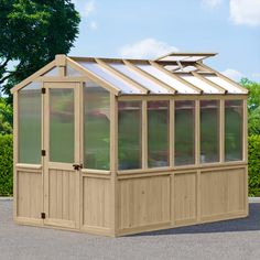 a small wooden greenhouse sitting on top of a parking lot