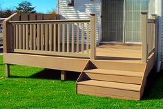 a porch with steps leading up to the front door and side walk out into the yard