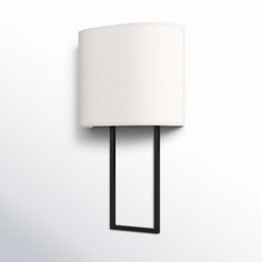 a wall light with a white shade on it's side and a black frame around the lamp