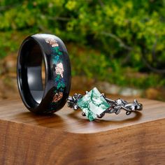 two wedding bands with flowers on them sitting on a wooden table next to each other