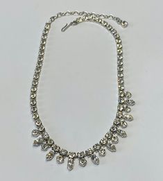 Beautiful silver tone and clear stone choker, perfect for a wedding, graduation or debutant.  This is a perfect accessory for that exciting night out.  This necklace is new new and has little to no signs of wear. Measurements:  42cm in total length, including the extender.  Square crystals are 0.5cm long and 0.5cm wide.  The round crystals are 0.5cm in diameter and the teardrop crystals are 1cm long and 0.5cm wide. Condition:  Excellent vintage condition.  No scratches, dents, or imperfections. Glamorous Silver Rhinestone Necklace For Anniversary, Silver Rhinestone Wedding Choker, Sparkling Crystal Rhinestone Necklace For Anniversary, Adjustable Rhinestone Necklaces For Wedding, Classic Silver Rhinestone Necklace For Wedding, Silver Party Choker With 17 Jewels, Classic Silver Wedding Choker, Classic Silver Choker For Wedding, Silver Choker With Sparkling Stones For Evening