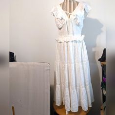 For Size Reference Was Modeled On A Small Mannequin. Brand New With Tags Attached, Also An Extra Button. White Cotton With A Pattern, See Pics For Close-Up. V Neck With A Tie At The Front, Lined Bodice Cups Sewn Onto An Elastic Panel That Circles Around To The Back. Sleeveless, Ruffles Around The Arm Openings, Band Buttons Onto The Back Edge. Small Ruffle Just Below The Waist With Gathering, Three Panels Below That In A Tier Design, Between The Last Two Is Lace. Flares Out Into A Full Calf Lengt Cottagecore V-neck Dress With Ruffles, Cottagecore Maxi Dress With Ruffles, Cottagecore Beach Dress With Ruffles, Cottagecore Ruffled Dresses For Brunch, Cottagecore Ruffled Dress For Vacation, Cottagecore Ruffle Beach Dress, Cottagecore Ruffled Beach Dresses, White Ruffle Hem Maxi Dress For Daywear, White Maxi Dress With Ruffle Hem For Daywear