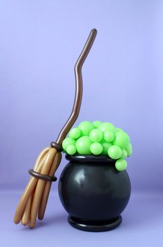 a black pot with green and brown balloons in it