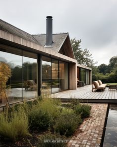 a house with large windows and wooden decking